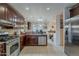 Well-lit kitchen with dark wood cabinetry, stainless steel appliances, and neutral tile flooring at 7131 E Cholla St, Scottsdale, AZ 85254