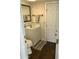 Compact bathroom with a white vanity, toilet, and wood-look flooring, creating a clean and efficient space at 7750 E Broadway Rd # 433, Mesa, AZ 85208