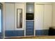 Built-in blue cabinets with a mirror and television in a bedroom, offering ample storage and functionality at 7750 E Broadway Rd # 433, Mesa, AZ 85208