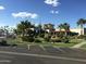 The Carriage Manor Resort clubhouse with manicured landscaping, a putting green, parking, and Arizona flags at 7750 E Broadway Rd # 433, Mesa, AZ 85208