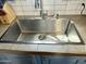 A stainless steel kitchen sink features a modern faucet and tile backsplash, set on a tile countertop at 7750 E Broadway Rd # 433, Mesa, AZ 85208