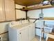 Convenient laundry area features a washer, dryer, overhead storage, and shelving for supplies at 7750 E Broadway Rd # 433, Mesa, AZ 85208