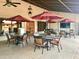 Outdoor patio at Carriage Manor Resort with tables, chairs, umbrellas and a ceiling fan at 7750 E Broadway Rd # 433, Mesa, AZ 85208