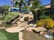 Landscaped water feature at Carriage Manor Resort, with waterfalls, rocks, plants, and stone steps at 7750 E Broadway Rd # 433, Mesa, AZ 85208