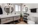 Modern bathroom featuring a double sink vanity, round mirrors, and stylish wood-look accents at 7811 N 32Nd Ave, Phoenix, AZ 85051