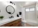 Modern bathroom featuring updated vanity, round mirror, and shower-tub combination at 7811 N 32Nd Ave, Phoenix, AZ 85051