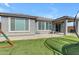Enjoy a private backyard, complete with artificial grass, a covered patio and play equipment at 797 W Danish Red Trl, San Tan Valley, AZ 85143