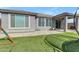 Enjoy a private backyard, complete with artificial grass, a covered patio and play equipment at 797 W Danish Red Trl, San Tan Valley, AZ 85143