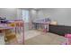 A bedroom featuring two pink bunk beds, a grey dresser and neutral carpeting at 797 W Danish Red Trl, San Tan Valley, AZ 85143