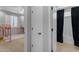 Hallway with white doors leading to a bedroom and a bathroom with a dark shower curtain at 797 W Danish Red Trl, San Tan Valley, AZ 85143