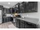 Modern kitchen featuring sleek black cabinetry, granite countertops, and stainless steel appliances at 797 W Danish Red Trl, San Tan Valley, AZ 85143
