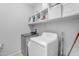 Laundry room with white cabinets above a stainless steel washer and white dryer at 797 W Danish Red Trl, San Tan Valley, AZ 85143