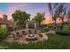 Inviting backyard patio with seating around a fire pit, a gazebo, and a charming rock waterfall feature at 8260 W Cielo Grande Ave, Peoria, AZ 85383