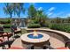 Inviting backyard with a stone fire pit, comfortable seating, and a tranquil water feature, ideal for relaxation at 8260 W Cielo Grande Ave, Peoria, AZ 85383