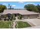 Charming home featuring a manicured lawn, mature trees, a tile roof, and a three-car garage at 8260 W Cielo Grande Ave, Peoria, AZ 85383