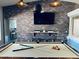 Pool table set against a brick wall with a TV, complemented by industrial lighting, blending recreation and style at 8260 W Cielo Grande Ave, Peoria, AZ 85383