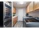 Bright laundry room with wooden cabinets, gray wood-look flooring, a wine fridge, and a modern washer and dryer at 8260 W Cielo Grande Ave, Peoria, AZ 85383