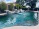 Sparkling pool with waterfall feature, surrounded by lush landscaping and offering a serene backyard oasis at 8260 W Cielo Grande Ave, Peoria, AZ 85383