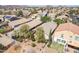 Aerial view of backyard with desert landscaping, mature trees, covered patio, and privacy, with a neighborhood backdrop at 85 W Grey Stone St, San Tan Valley, AZ 85143