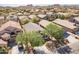 Aerial view of a well-manicured neighborhood showcasing desert landscaping, mature trees, and mountain views at 85 W Grey Stone St, San Tan Valley, AZ 85143