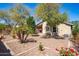 Well-maintained backyard showcases desert landscaping, mature trees, and a covered patio, perfect for outdoor enjoyment at 85 W Grey Stone St, San Tan Valley, AZ 85143