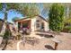 Charming backyard with a covered patio, desert landscaping, mature shade trees, and a dining area for outdoor dining at 85 W Grey Stone St, San Tan Valley, AZ 85143