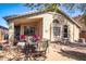 Welcoming backyard patio offers a dining area, covered seating, lush potted plants, and desert landscaping at 85 W Grey Stone St, San Tan Valley, AZ 85143