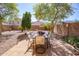 Inviting backyard patio area featuring a dining table set perfect for outdoor entertaining under mature shade trees at 85 W Grey Stone St, San Tan Valley, AZ 85143