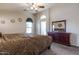 Comfortable bedroom featuring ceiling fan, large dresser with mirror, and sunburst decorations at 85 W Grey Stone St, San Tan Valley, AZ 85143