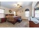 A cozy bedroom with neutral walls, carpet, a large mirror, and a king-size sleigh bed at 85 W Grey Stone St, San Tan Valley, AZ 85143