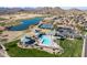 Aerial view of community amenities showcasing a pool, tennis courts, playground, lake, and golf course at 85 W Grey Stone St, San Tan Valley, AZ 85143