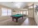 Spacious game room with a pool table, carpet, and a transition to wood flooring near the front door at 85 W Grey Stone St, San Tan Valley, AZ 85143