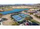 Aerial view showcasing community tennis and pickleball courts by a lake and golf course at 85 W Grey Stone St, San Tan Valley, AZ 85143