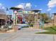 Community Adventure Playground, featuring colorful equipment, surrounded by lush landscaping and blue skies, offers outdoor fun for families at 8559 W Trenton Ct, Florence, AZ 85132