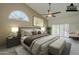 Bright bedroom featuring a ceiling fan, large window, and neutral color palette at 9130 W Rimrock Dr, Peoria, AZ 85382