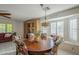 Cozy dining area with round wooden table, floral chairs, and natural light from a large window at 9130 W Rimrock Dr, Peoria, AZ 85382