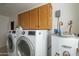 Efficient laundry room featuring modern washer and dryer, along with convenient overhead cabinet storage at 9130 W Rimrock Dr, Peoria, AZ 85382