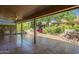 Charming covered patio with tile flooring, fan, and view of well-maintained garden and desert landscaping at 9130 W Rimrock Dr, Peoria, AZ 85382