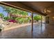 Inviting covered patio with tile flooring and view of beautifully landscaped backyard and water feature at 9130 W Rimrock Dr, Peoria, AZ 85382