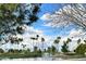Scenic view of a pond with a fountain on a golf course, framed by palm trees and blue skies at 9130 W Rimrock Dr, Peoria, AZ 85382