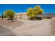 Side view of single-story home with desert landscaping, bright green trees, and mountain views at 9736 E Sleepy Hollow Trl, Gold Canyon, AZ 85118