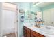 Well-lit bathroom with dual sinks, a large mirror, and a shower with a curtain at 10037 W Watkins St, Tolleson, AZ 85353