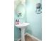 Charming powder room with pedestal sink, decorative accents, and soft blue walls at 10037 W Watkins St, Tolleson, AZ 85353