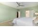 Bright bedroom with light hardwood floors, neutral walls, ceiling fan, and en-suite bath at 10037 W Watkins St, Tolleson, AZ 85353