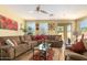 Comfortable living room with a cozy sectional, ceiling fan, and bright natural light at 10037 W Watkins St, Tolleson, AZ 85353