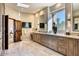 Large bathroom showcasing dual sinks, wooden cabinets, and a bright window with a scenic view at 10067 E Santa Catalina Dr, Scottsdale, AZ 85255