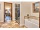 Bathroom showcasing a glass-enclosed shower, tub, and doorway to another room at 10067 E Santa Catalina Dr, Scottsdale, AZ 85255