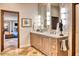 Elegant bathroom with dual sinks, stone counters, wood cabinets and decorative accents at 10067 E Santa Catalina Dr, Scottsdale, AZ 85255