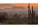 Distant view features iconic saguaros set against a backdrop of majestic mountains at dusk at 10067 E Santa Catalina Dr, Scottsdale, AZ 85255