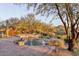 Beautiful backyard pool with natural rock accents, surrounded by desert landscaping at 10067 E Santa Catalina Dr, Scottsdale, AZ 85255